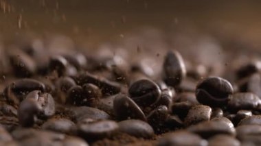 Yavaş çekimde kahve çekirdekleri düşüyor. 1000 fp hızla havaya toz saçılıyor.