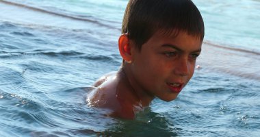 Yaz tatillerinde yüzme havuzunda aktif bir genç çocuk.