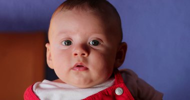 Handsome baby boy portrait wearing infant observing