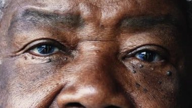 Afrikalı Amerikalı kıdemli kadının yakın plan portresi kameraya ciddi bir ifadeyle bakıyor ve 80 'li yaşlarda bilgelik ve deneyim gösteriyor.