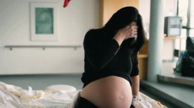 Hastane kliniğinde doğum öncesi kasılmalar sırasında ağrıyan hamile bir kadının dramatik sahnesi, doğum sancısı çeken bir hastanın yüzü.