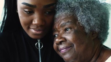 Sevecen, genç Afrikalı Amerikalı torunu, 80 'li yaşlarda yaşlı büyükannesine bakıyor. Gri saçlı, düşünceli, yaşlı kadın nesiller arası bağ kuruyor.