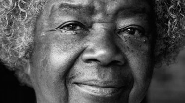 Yaşlılıkta resmi Afrikalı Amerikalı kadın portresi, 80 'li yaşlarda kırışıklıkları ve gri saçları olan yetişkin bir kadın siyah beyaz tek renkli kameraya bakıyor.