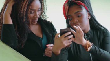 20 'li yaşların Kızı, Çevrimiçi İçeriği Anne ile paylaşıyor, ekranda internetteki eğlence medyasına işaret ediyor, Smartphone Bonding