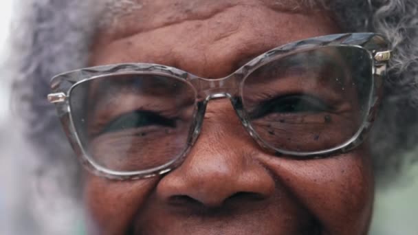 一位快乐的80多岁的老年黑人妇女 戴着大大的眼镜 对着相机微笑 非洲裔老年人的紧闭面带微笑 — 图库视频影像