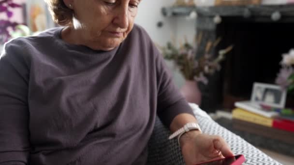 Пожилая Женщина Читает Контент Онлайн Держа Мобильное Устройство Время Сидения — стоковое видео