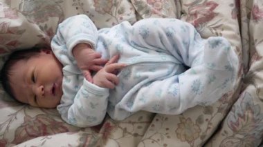 Yeni doğmuş bebek, hayatının ilk haftası boyunca bebek açısından dünyaya yukarıdan bakarak yatağa uzandı.