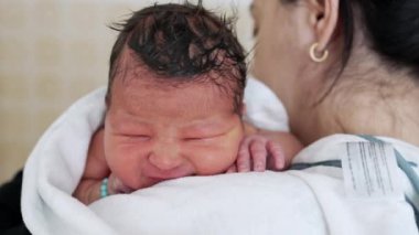 Yeni doğmuş bebek banyo sonrası annesinin omzunu gevşetiyor. Bebekliğin ilk günleri anne tarafından teselli edilmek, anne bakımı...