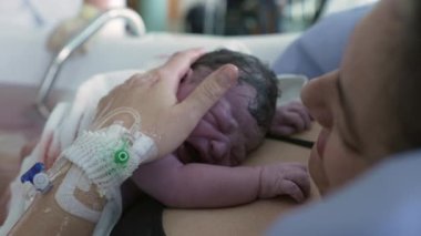 Anne doğumdan sonra yeni doğan bebeğini kucaklar, bebek doğumdan sonra annesinin göğsünde ağlar, ilk ağlamalar, hastanedeki ilk saniyeler