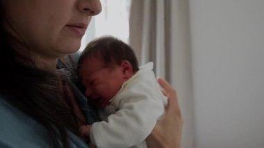Yorgun bir anne kucağında yeni doğmuş bir bebekle yatar, ayakta durmaktan yorgun düştükten sonra dinlenir. Yaşamın ilk günlerinde bebek
