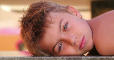 Handsome child young small boy looking to camera outdoors