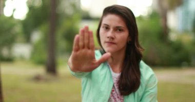 Millennial girl rejecting with hand blocking symbol