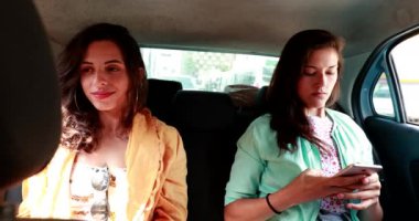 Two girls in the back of car taxi