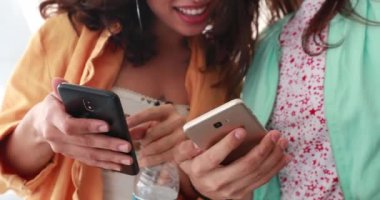 Girlfriends checking cellphone device laughing and smiling