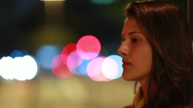 Düşünceli genç bir kadın geceleri şehirde düşünüyor.