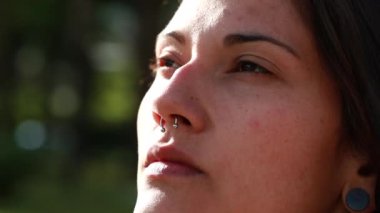 Genç bir kadın gökyüzüne umutla ve inançla bakıyor.