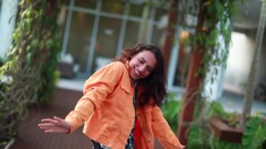 Kameraya gülümseyen genç bir kadın. İyi haberleri kutlayan kız.