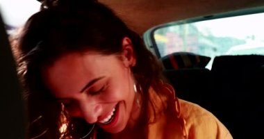 Kadın arabanın arka koltuğunda kendiliğinden gülüyor. Gerçek hayatta kız güler ve gülümser.