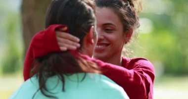 Female friends talking in conversation outdoors, empathic listening