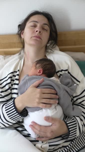 ナプシーン 母と新生児が幼児期のベッドで一緒に眠った後 垂直ビデオ 胸に抱かれている乳児 — ストック動画