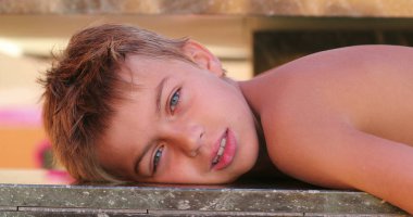 Small boy resting after pool laying down