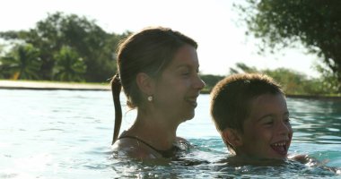 Mother and child at the swimming pool mom embracing son at the pool