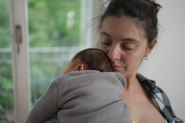 Sevgi dolu bir anne yeni doğmuş bebeğini kucağına alır, gözleri huzurlu bir şekilde bağlanır, sıcacık evlerinde sıcaklığı ve şefkati yayar..