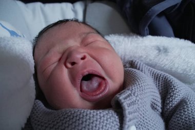 Uyurken gülümseyen yeni doğmuş bir bebeğin yakın çekimi. Saf bir mutluluk ve mutluluk anı yakalıyor..