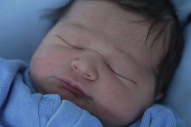 Hastanede yeni doğmuş bir bebeğin huzur içinde uyuması sakin ve besleyici bir ortamda yeni bir hayatın masumiyetini ve huzurunu vurguluyor.