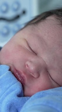 Hastanede yeni doğmuş bir bebeğin huzur içinde uyuması, sakin ve besleyici bir ortamda yeni bir hayatın masumiyetini ve huzurunu ön plana çıkarıyor.