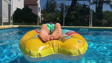 Çocuk şişme yatakta dinleniyor.