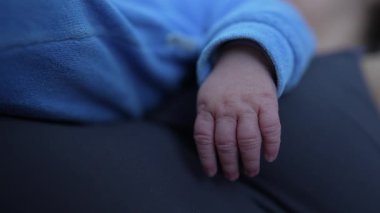 Yeni doğmuş bir bebeğin minik elinin yakın çekimi hassas ve karmaşık ayrıntıları vurguluyor hassas ve yürek ısıtan bir anda yeni hayatın güzelliğini ve kırılganlığını vurguluyor.