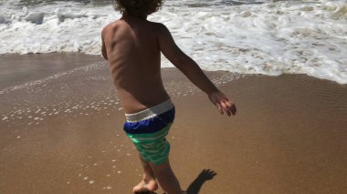 Kumsalda oynarken yürümeye başlayan çocuk