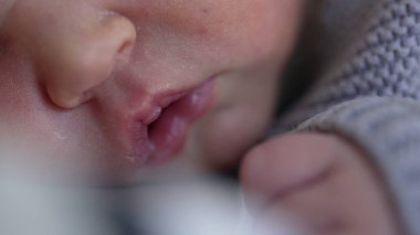 Yeni doğmuş bebek yüzünün makro yakın çekimi ve hayatın ilk günlerinde minik eller. Varoluşunun ilk haftasında bebek.