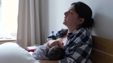 Anne bebeğini emzirirken rahatsızlık hissediyor, emzirmenin zorluklarını ve gerçeklerini kavrıyor ve annelerin çocuklarını büyütmedeki güç ve kararlılığını vurguluyor.