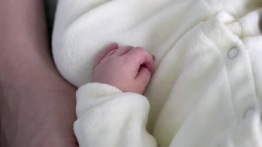 Yeni Doğanların Eli 'nin Yakın Çekimi Yumuşak Beyaz Battaniyede Dinleniyor, Minik Parmakları Gösteriyor ve Zarif Derisi Huzurlu ve Huzurlu Bir Ayarda 