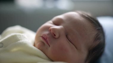 Yeni doğmuş bebek rahat beyaz bir kıyafetle huzurlu bir şekilde uyuyor, sakin ve rahat bir yüz ifadesi sergiliyor. masumiyet, sükunet ve yeni bir hayat.