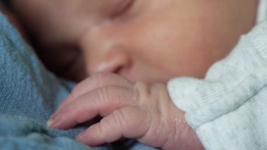 Uyurken yeni doğmuş bir bebeğin elinin ebeveynin göğsüne nazikçe uzanması. ebeveyn ve çocuk arasındaki hassas ve samimi bağ