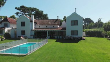 Home house exterior with lawn and swimming pool