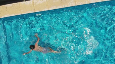 Çocuk havuzdan çıkıyor, havuzda oynayan çocuğun dikey hava perspektifi