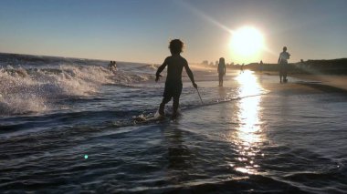 Sahilde oynayan küçük çocuk, siluet