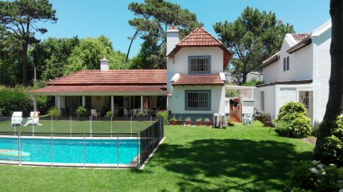 Suburban home exterior revealing pool and lawn