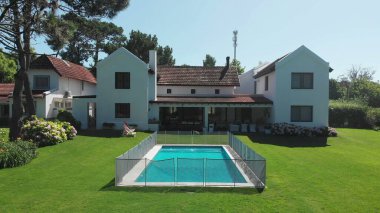 Beautiful exterior of home. green grass and swimming pool