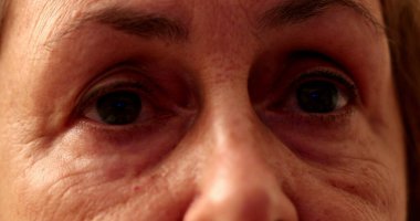 Üst düzey kadın televizyon izlerken yakından bakıyor.