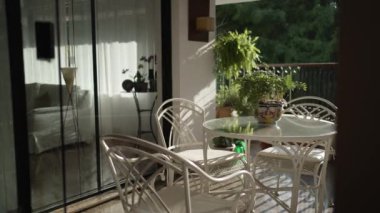 Beyaz sandalyeli ve masalı modern bir terasın iç tasarımı.