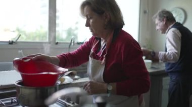 Son sınıf çifti mutfakta birlikte yemek pişiriyor.