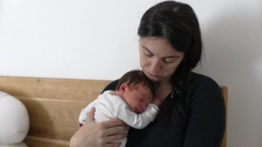 Anne laptopta çalışmak ile bebeğine bakmak arasında gidip geliyor. Modern çalışan ebeveynlerin gerçekliğini gösteriyor. Mesleki görevlerini ebeveynlik, sevgi ve evdeki aile sorumluluklarıyla dengeliyor.