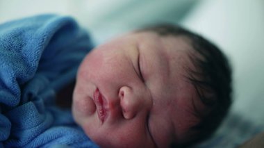 Yeni doğan bebeğinin doğumdan sonraki ilk gününde uyuduğu yakın plan. Bebek hayatının ilk saatleri uyuyordu.