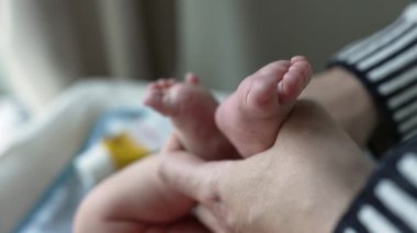 Bebek ayaklarının nazikçe tutulduğu yakın plan bebekliğin hassas doğasını ve hassas bakımını vurguluyor. Yetiştirici bir ortamda yeni doğmuş bir bebeğin yumuşaklığı ve masumiyeti.