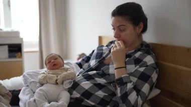 Anne kucağında yeni doğmuş bebeği tutuyor, sessiz bir jest yapıyor, annelik ve huzur verici bir an, anne ve bebek arasındaki barışçıl ve sakinleştirici etkileşimi vurguluyor.
